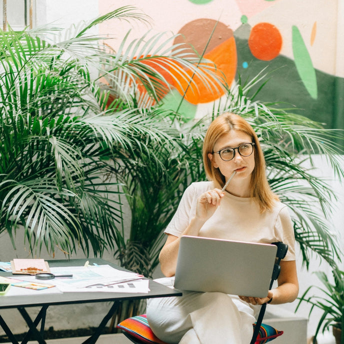  A seated woman holding a laptop and thinking. Photo courtesy of Nataliya Vaitkevich  
