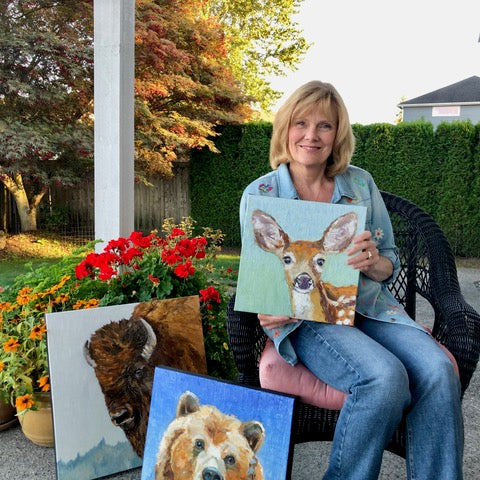  UGallery artist Karen Barton holding one of her animal portrait paintings 