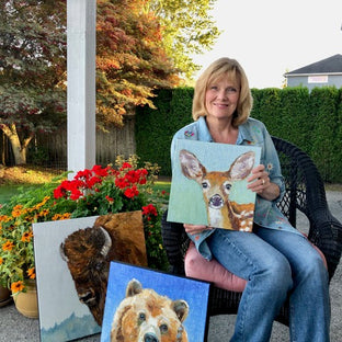  UGallery artist KB Barton holding one of her animal portrait paintings 