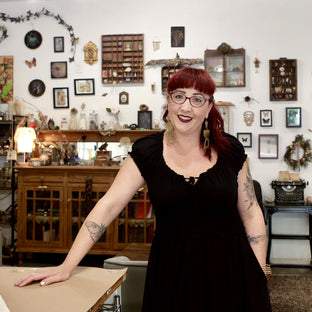 UGallery artist Shannon Amidon smiling in her art-filled studio 