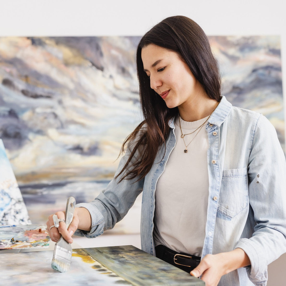  UGallery artist Tiffany Blaise working on a painting in her studio 