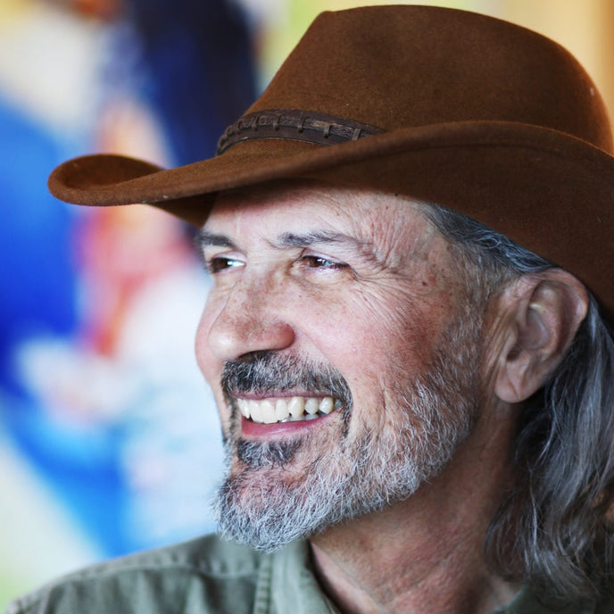  Close-up portrait of UGallery artist Warren Keating, smiling and wearing a brown cowboy hat 