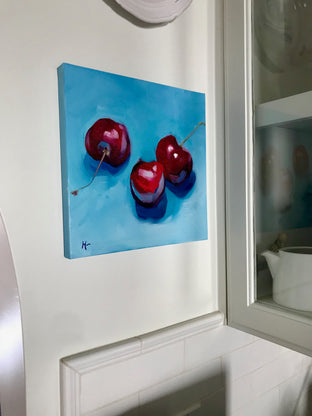 Original art for sale at UGallery.com | Three Cherries on Blue by Malia Pettit | $275 | oil painting | 10' h x 10' w | photo 3